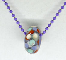 Load image into Gallery viewer, Purple core with orange, purple and light blue encased in clear glass bead on ball chain