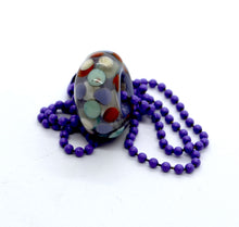 Load image into Gallery viewer, Purple core with orange, purple and light blue encased in clear glass bead on ball chain